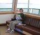 [Kathy on ferry reading Latitude 38]