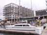 [KatieKat docked in front of apartments under construction]